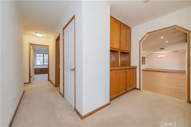 an empty room with chandelier fan and windows