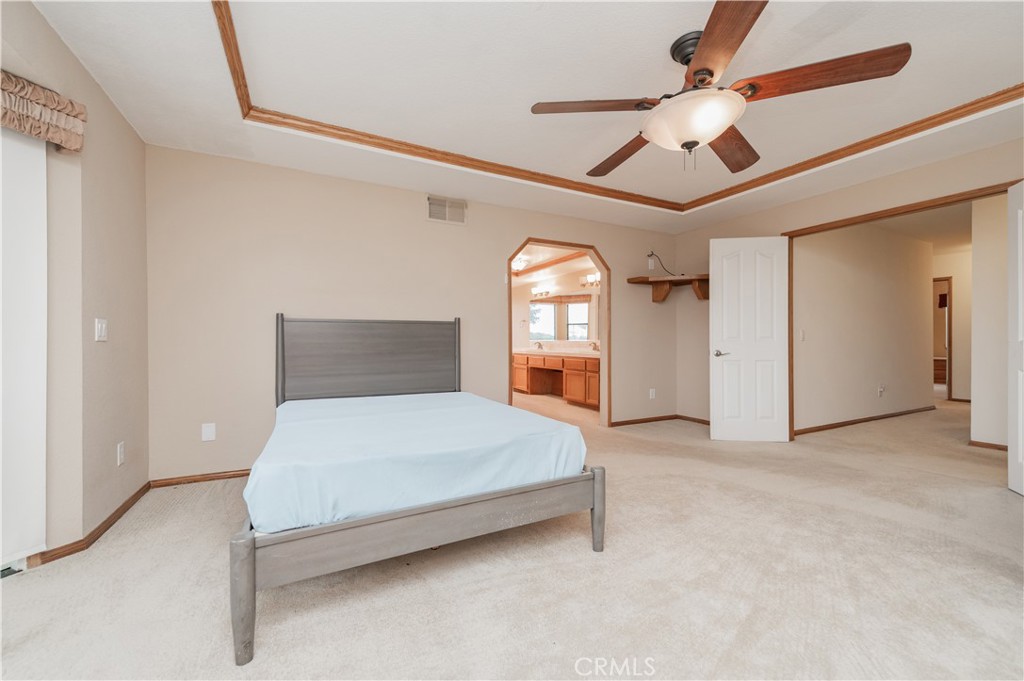 9539 Soledad Road Pinon Hills, CA 92372 - Photo 40 of 66 a spacious bedroom with a bed and a chandelier