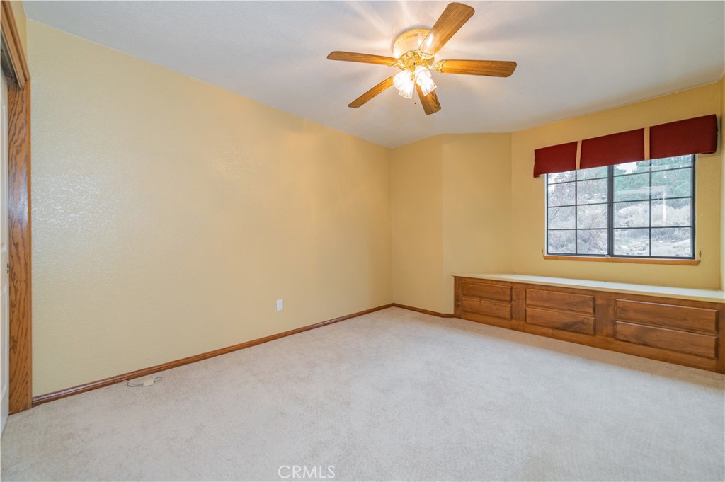 9539 Soledad Road Pinon Hills, CA 92372 - Photo 49 of 66 an empty room with chandelier fan and windows