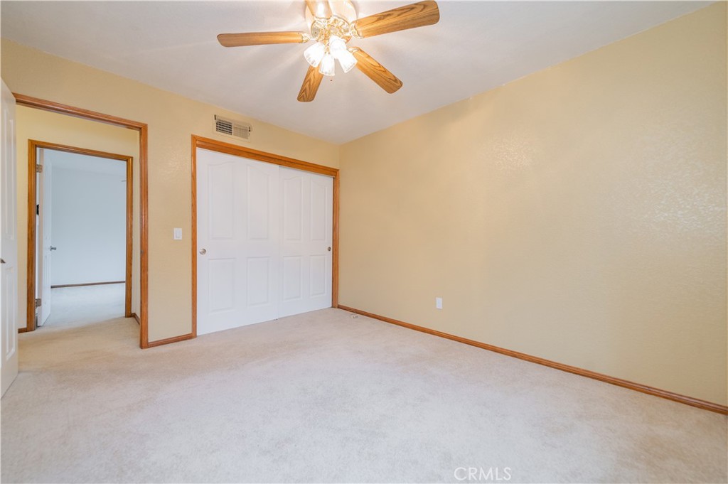 9539 Soledad Road Pinon Hills, CA 92372 - Photo 50 of 66 an empty room with a chandelier fan and closet area