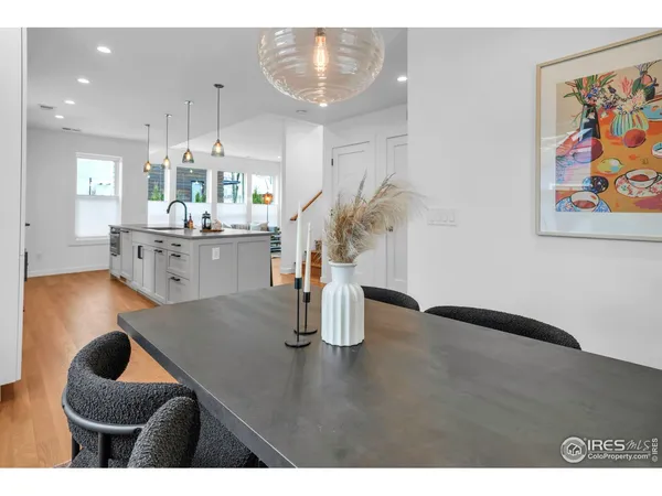 a kitchen with stainless steel appliances granite countertop a sink dishwasher and white cabinets with wooden floor