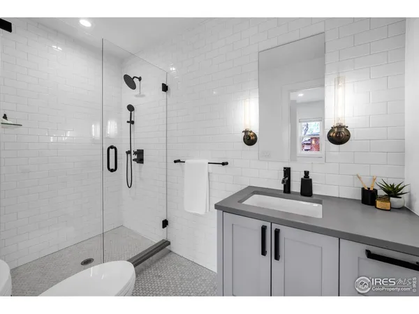 a bathroom with a sink vanity granite tub shower and mirror