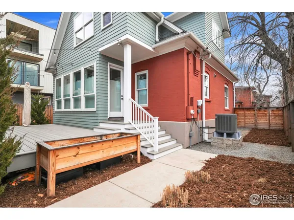 a backyard of a house with barbeque oven table and chairs