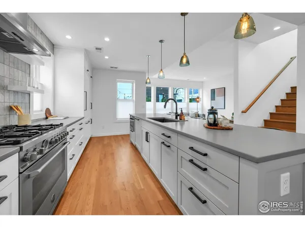 a kitchen with stainless steel appliances a stove a sink a counter space and cabinets