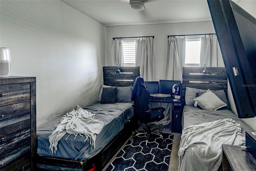 25190 Southwest 107th Avenue Homestead, FL 33032 - Photo 19 of 57 a bed sitting in a bedroom next to a window with pc