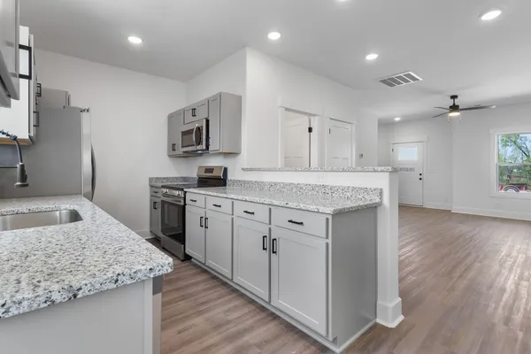 a kitchen with stainless steel appliances granite countertop a sink stove and refrigerator