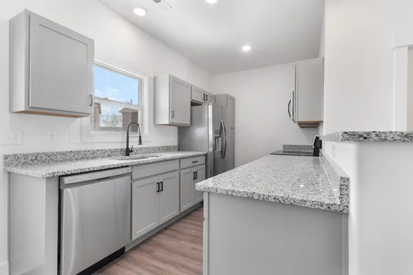 a kitchen with stainless steel appliances granite countertop a sink stove and refrigerator