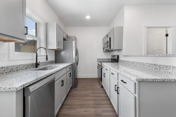 a kitchen with stainless steel appliances granite countertop a sink stove and cabinets