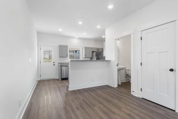 a view of a kitchen with wooden floor and electronic appliances