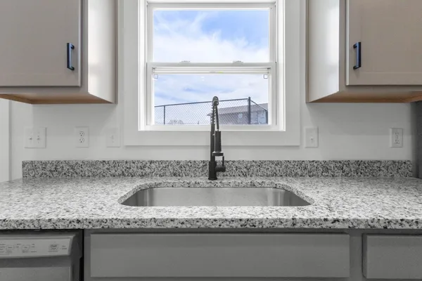 a kitchen with granite countertop a sink and a window