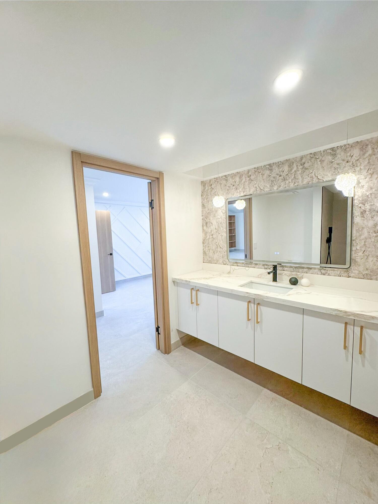 5630 Coach House Circle, Unit D Boca Raton, FL 33486 - Photo 20 of 26 a large white room with a mirror and a sink