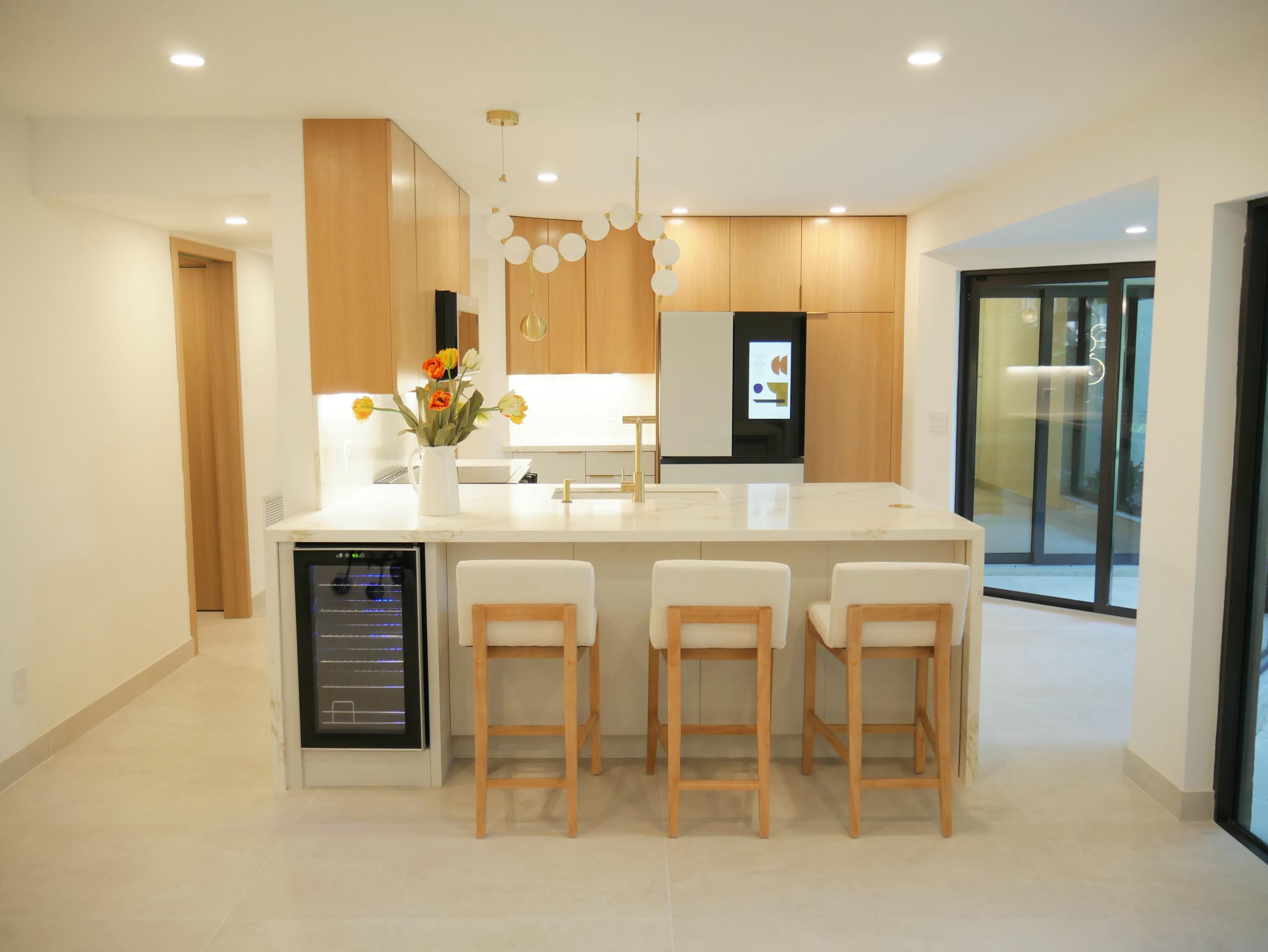 5630 Coach House Circle, Unit D Boca Raton, FL 33486 - Photo 5 of 26 a dining hall with stainless steel appliances kitchen island a table and chairs in it