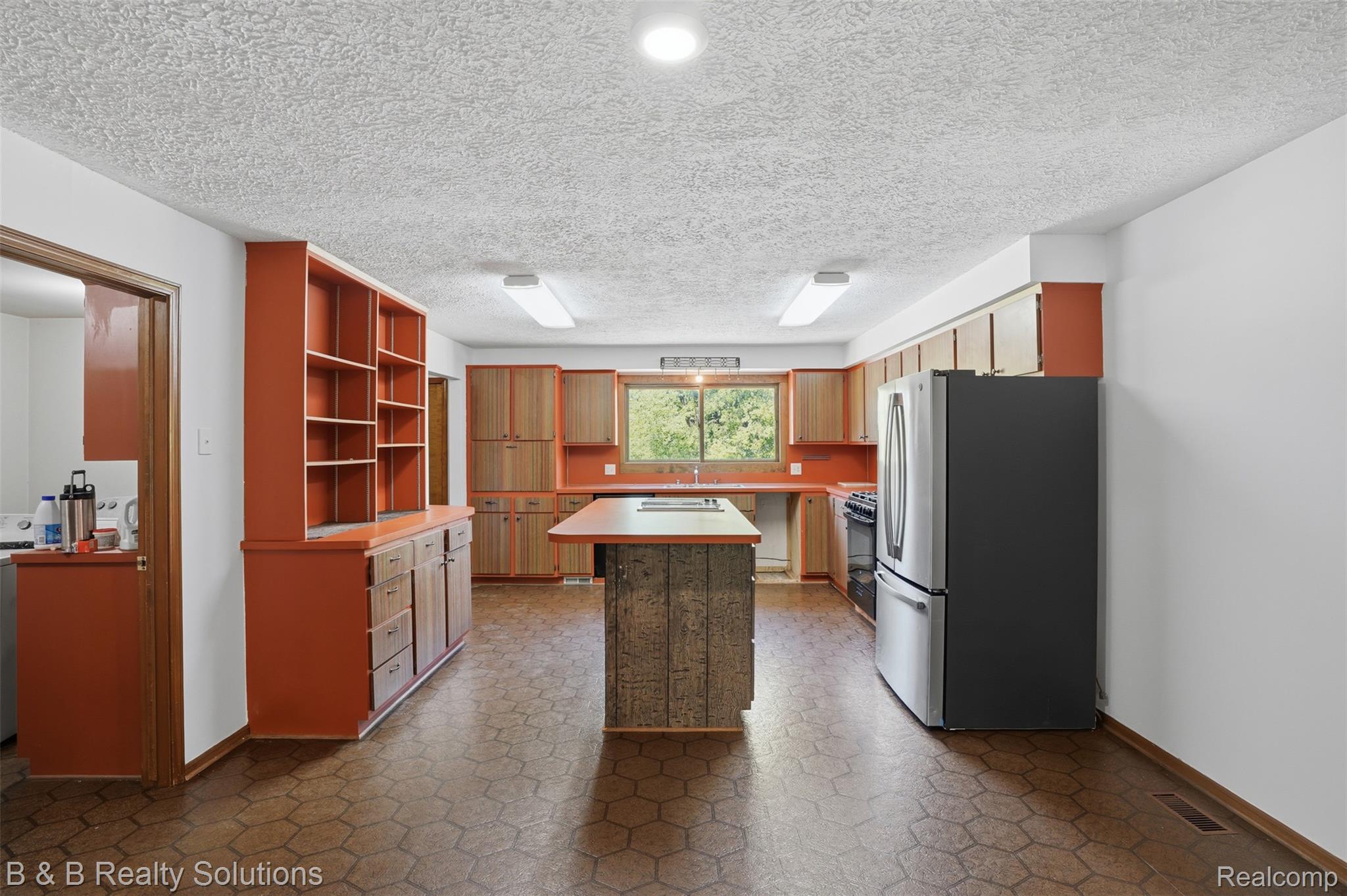 780 North Van Dyke Road, Unit APARTMENT #1 Almont, MI 48003 - Photo 11 of 28 Kitchen featuring an island with wood-finish paneling, extensive cabinetry, a double-basin sink, and recessed lighting