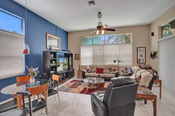 a living room with furniture a flat screen tv and a window
