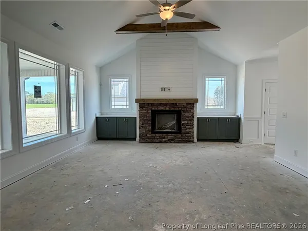 an empty room with a fireplace and windows