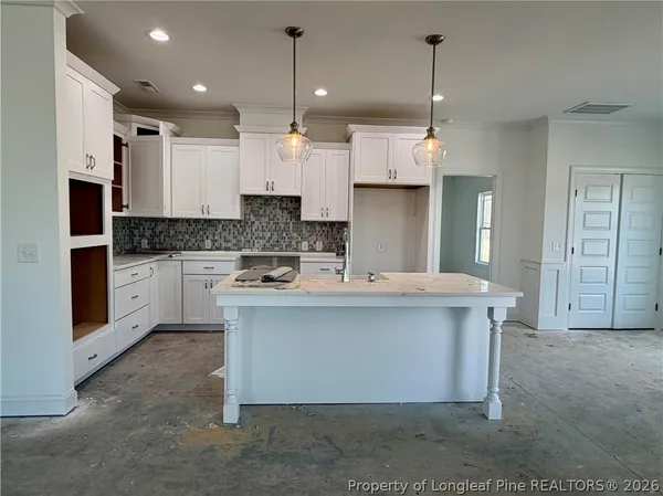 a large kitchen with stainless steel appliances kitchen island granite countertop a stove a sink a refrigerator a center island a stove and a window