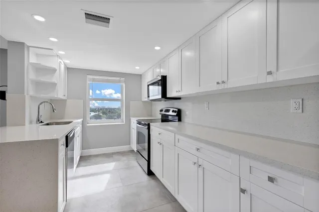 a kitchen with cabinets appliances a sink and a counter top space