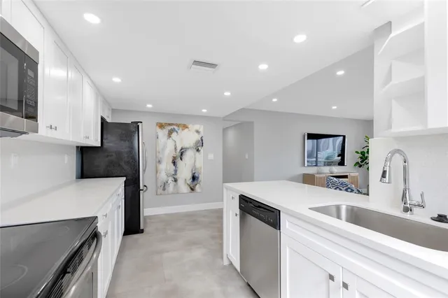 a kitchen with a sink stainless steel appliances and cabinets