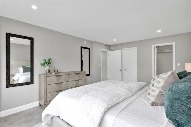 a bedroom with a large bed and a chandelier