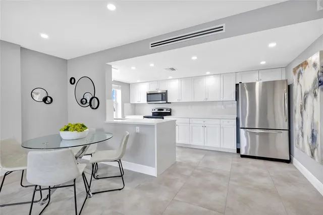 a kitchen with stainless steel appliances granite countertop a refrigerator and a stove top oven