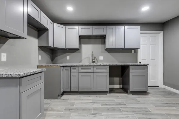 a kitchen with granite countertop a sink stainless steel appliances and cabinets