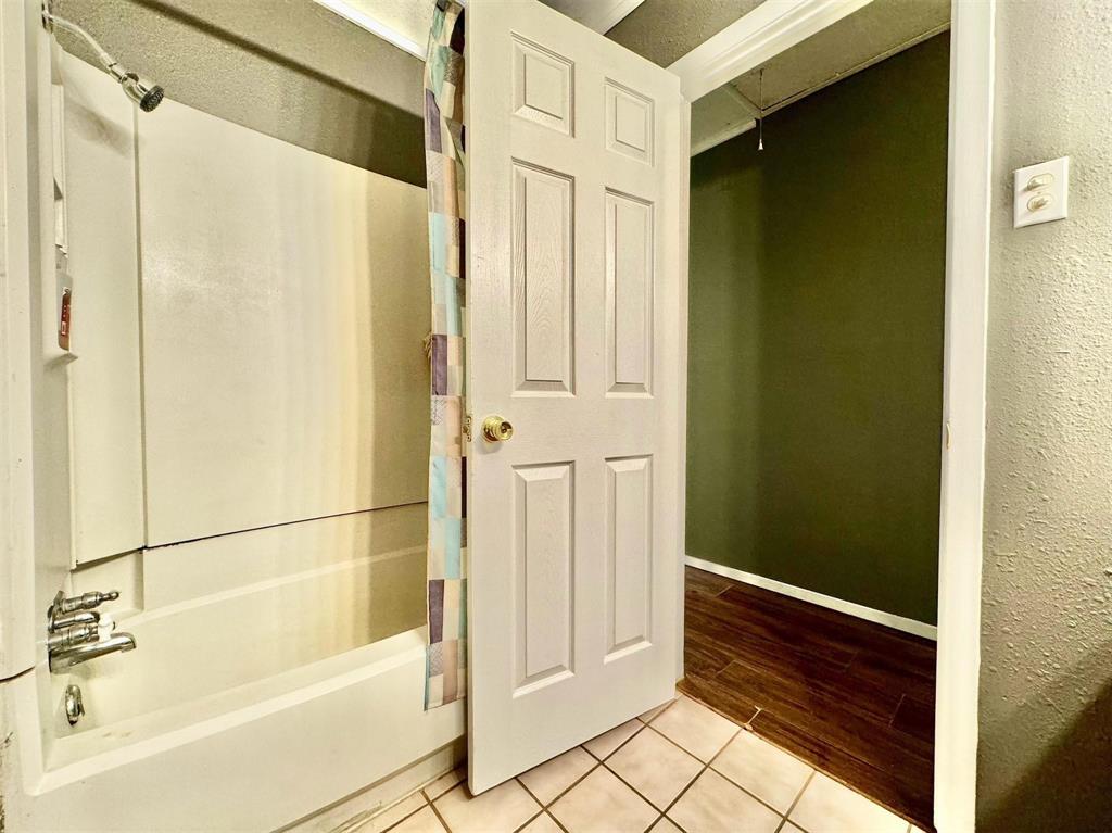 1319 West Morgan Street Denison, TX 75020 - Photo 11 of 17 a bathroom with a shower and a tub