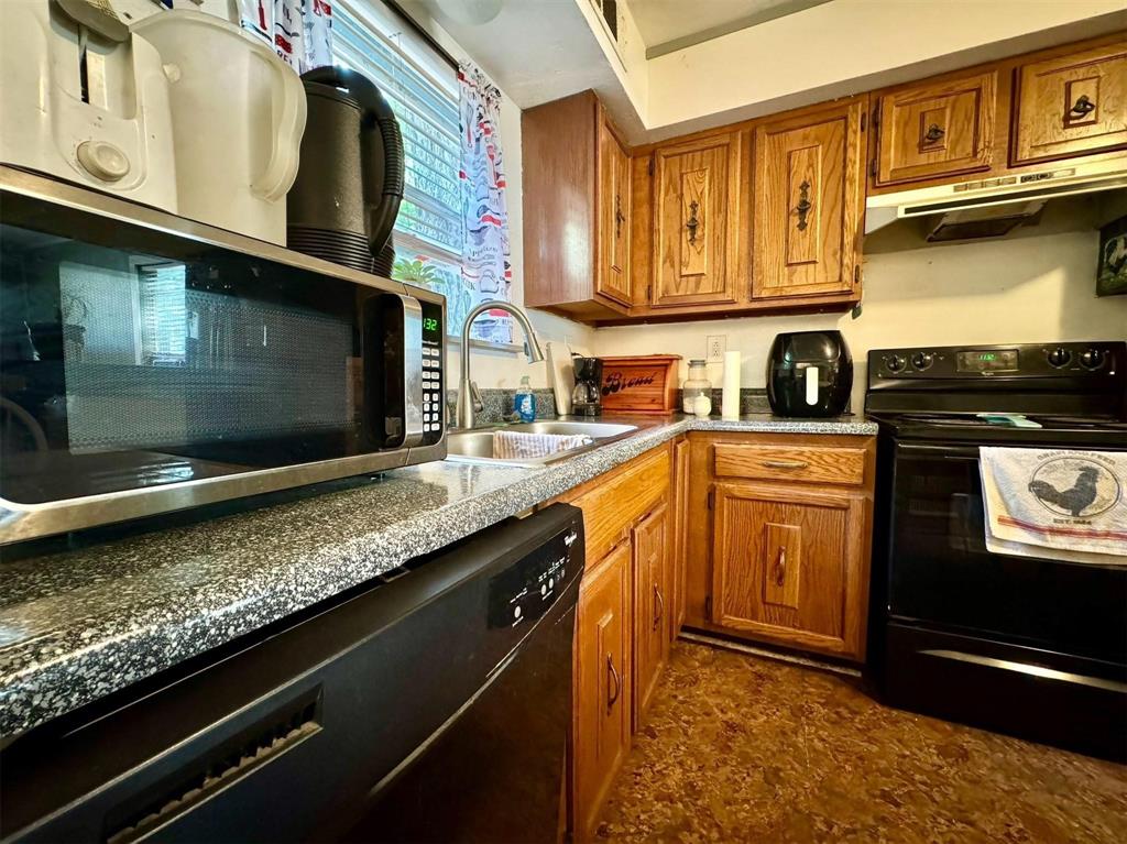 1319 West Morgan Street Denison, TX 75020 - Photo 5 of 17 a kitchen with stainless steel appliances granite countertop a sink stove and microwave