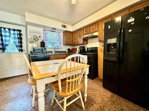 a kitchen with a table chairs refrigerator and cabinets