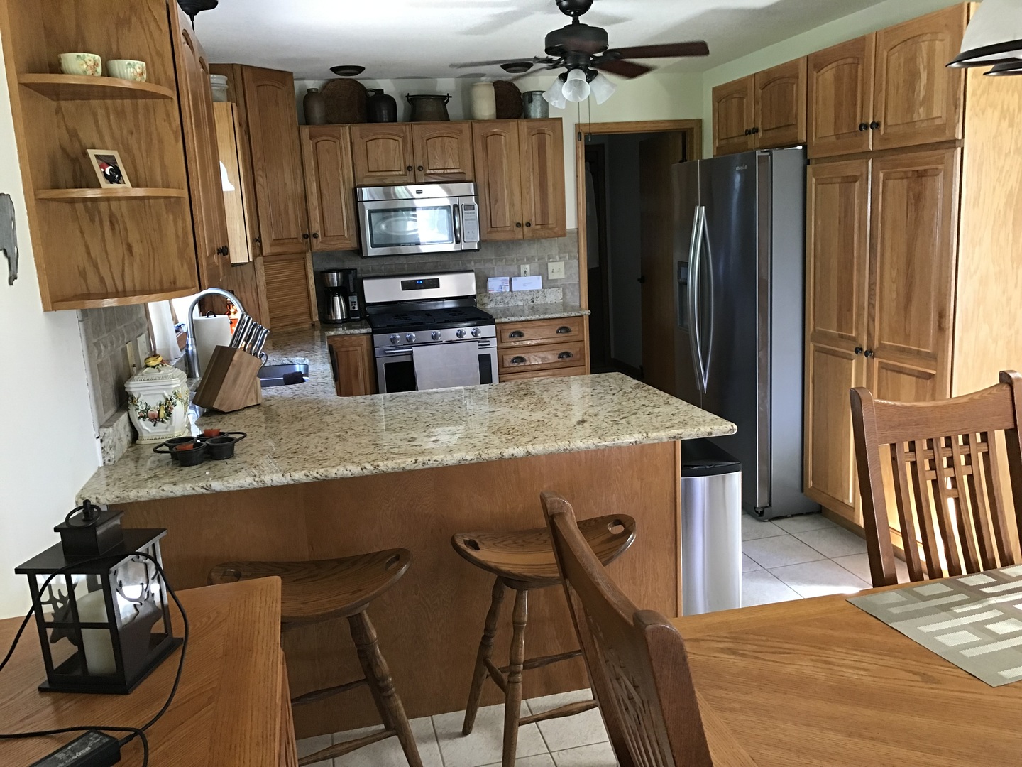115 Seneca Lane Loda, IL 60948 - Photo 7 of 21 a kitchen with stainless steel appliances granite countertop a refrigerator a stove a sink a dining table and chairs with wooden floor