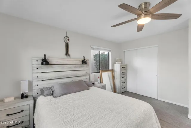 a bedroom with a bed and a ceiling fan