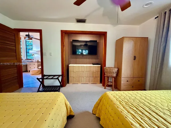 a bedroom with a bed and a dresser next to a window