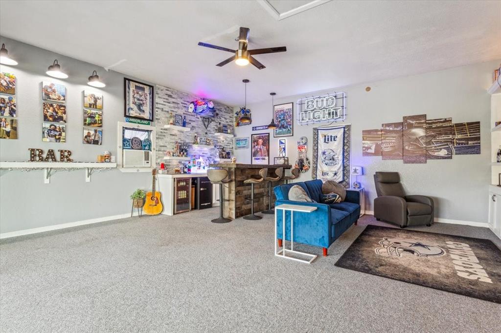 3356 Kattner Road Riesel, TX 76682 - Photo 26 of 40 Carpeted living room with baseboards, a ceiling fan, and a bar
