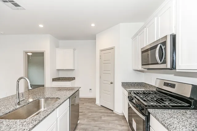 a kitchen with stainless steel appliances a refrigerator sink and stove