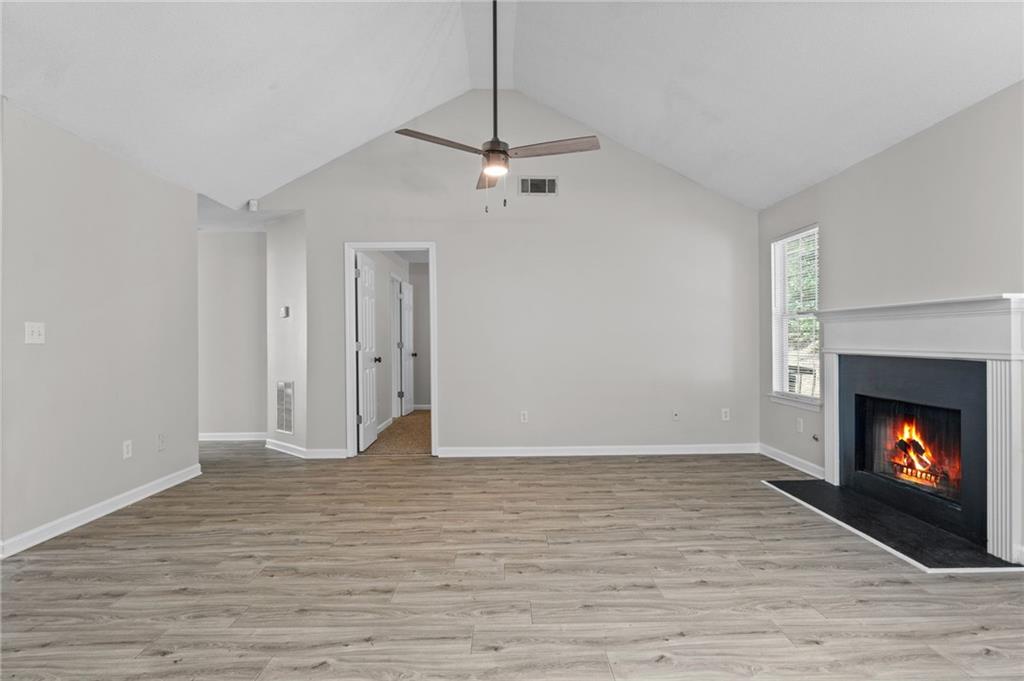 2921 Ward Lake Way Ellenwood, GA 30294 - Photo 13 of 25 a view of an empty room with wooden floor fireplace and a window