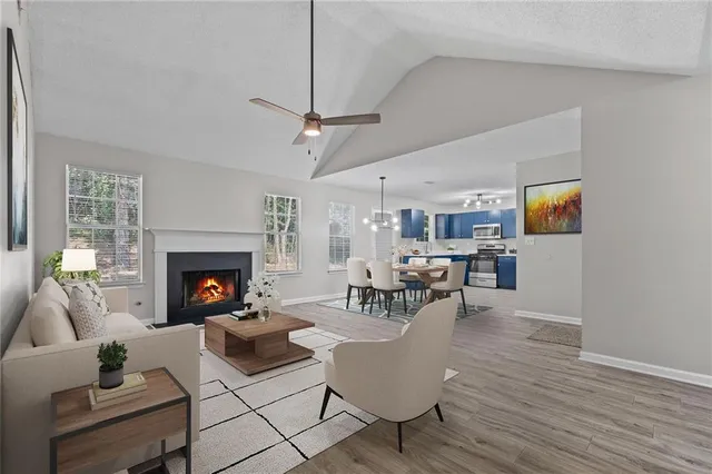a view of an empty room with wooden floor fireplace and a window