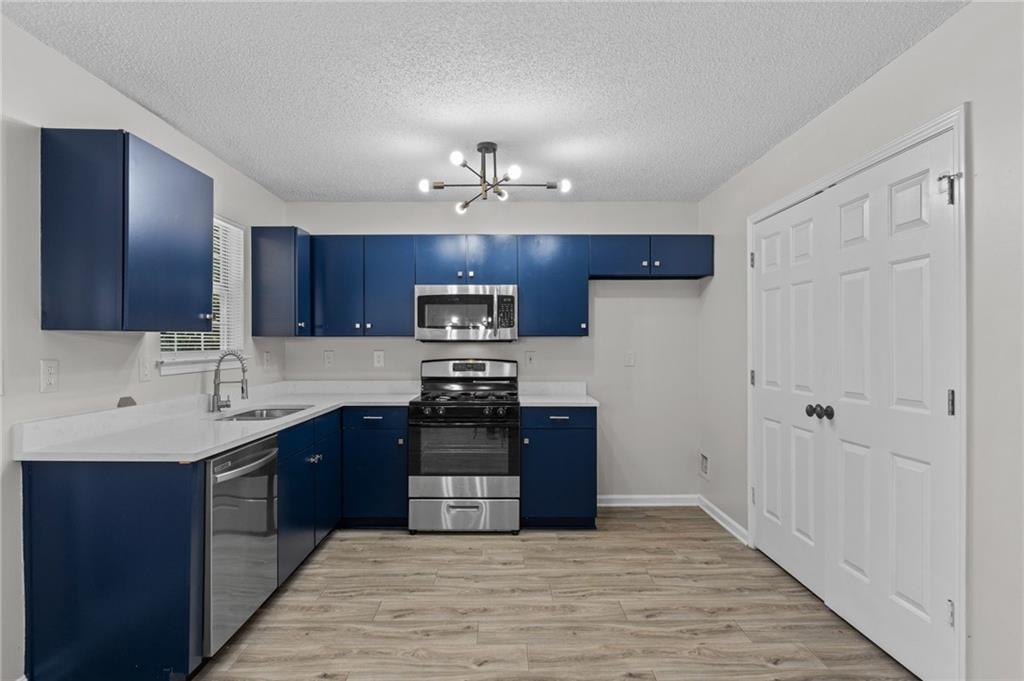 2921 Ward Lake Way Ellenwood, GA 30294 - Photo 8 of 25 a kitchen with stainless steel appliances granite countertop a refrigerator and a stove top oven