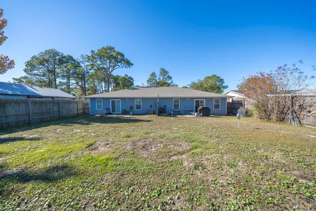 a front view of house with yard and trees in the background
