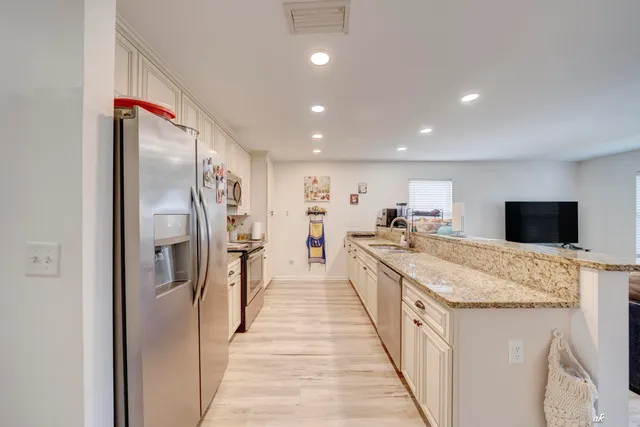 a large kitchen with stainless steel appliances kitchen island a stove a refrigerator and a sink