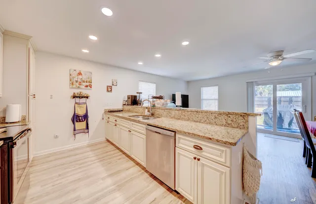 a large kitchen with kitchen island a stove a sink a refrigerator and cabinets