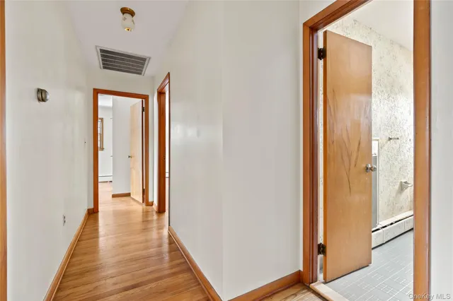 a view of empty room with wooden floor