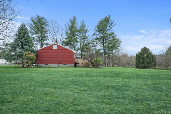 a view of a chairs in a big yard with large trees