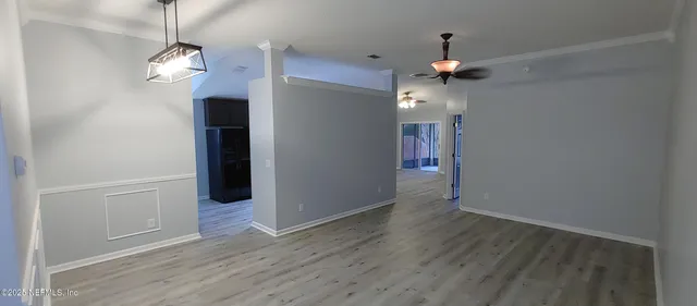 a view of a hallway with wooden floor and a chandelier