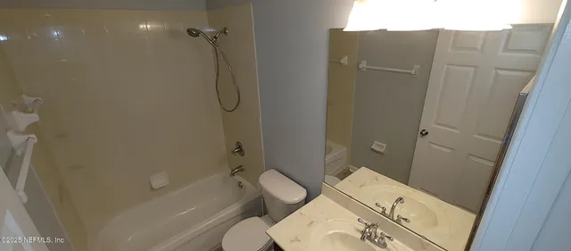 a bathroom with a granite countertop toilet sink and shower