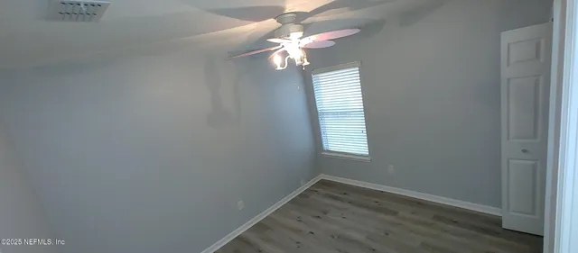 en empty room with wooden floor and windows