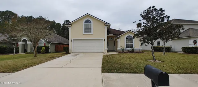 a front view of a house with a yard and trees