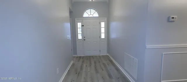 a view of a hallway with wooden floor