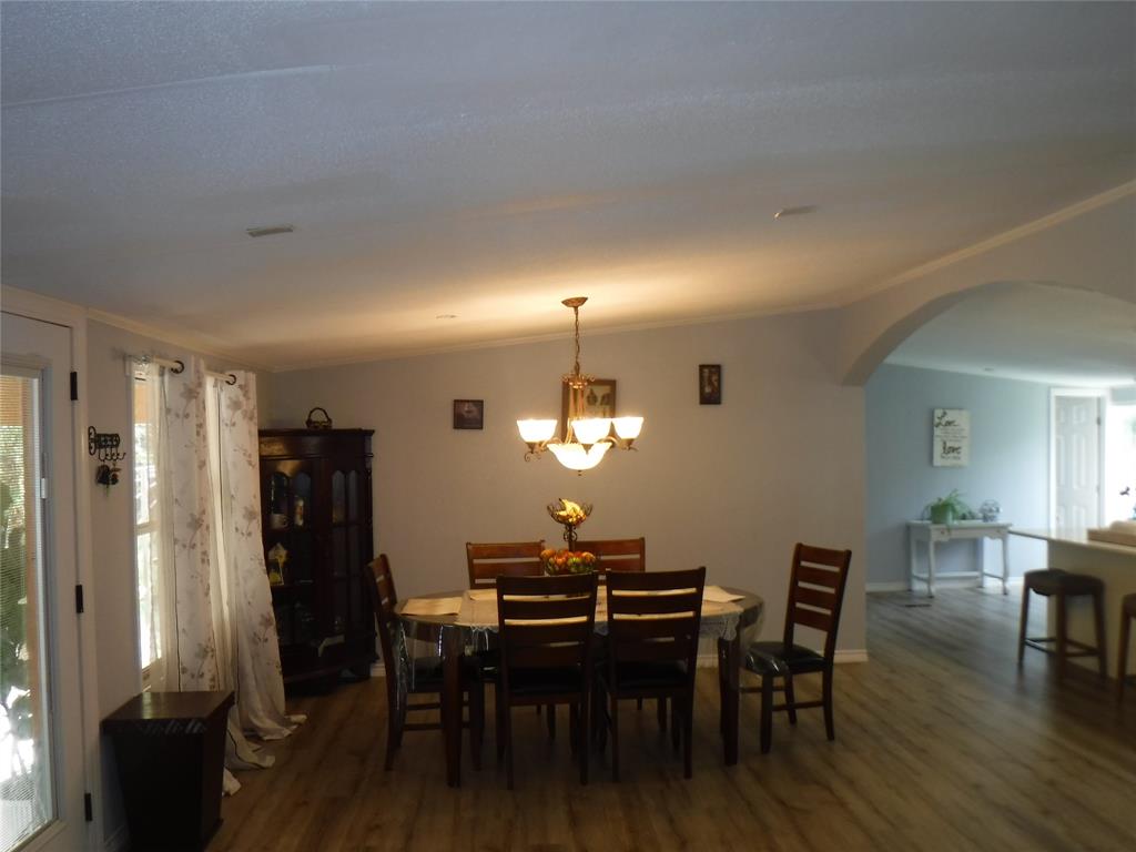191 Hickory Lane Elgin, TX 78621 - Photo 7 of 18 An inviting dining area features a warm chandelier and durable wood flooring.