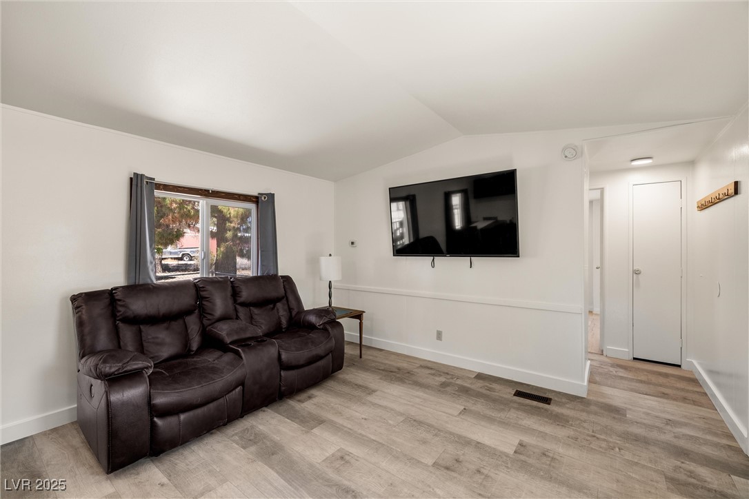 1771 East Brian Road Pahrump, NV 89048 - Photo 13 of 29 Living room featuring vaulted ceiling and light wood finished floors