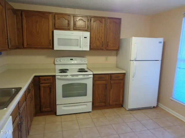 a kitchen with a stove top oven and cabinets