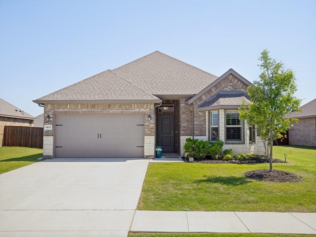 Brick and stone facade residence featuring an attached two-car garage